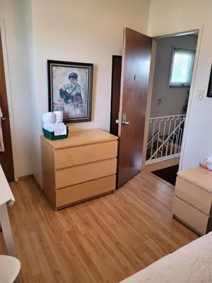 a room with a bedroom with a door and a dresser at The Dewberry Homestay B&B in Edmonton