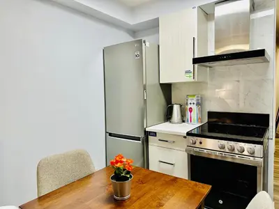 a kitchen with a wooden table and a stainless steel refrigerator at Romantic Studio with Kitchen & AC & BBQ & a Huge Balcony 164 in Canmore