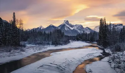 a river in the snow with mountains in the background at Romantic Studio with Kitchen & AC & BBQ & a Huge Balcony 164 in Canmore