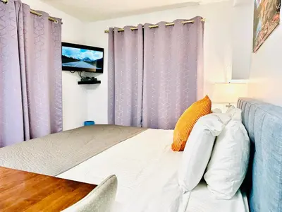 a bedroom with purple curtains and a bed at Romantic Studio with Kitchen & AC & BBQ & a Huge Balcony 164 in Canmore