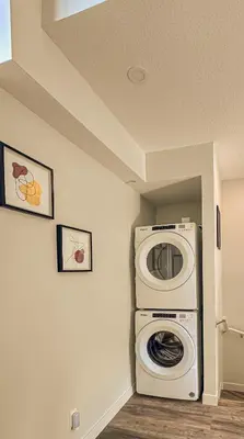 a laundry room with a washer and a washing machine at Skyline Escape - Mountain Views - Hot Tub - Pool in Canmore
