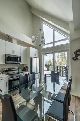 a dining room with a glass table and chairs at Skyline Escape - Mountain Views - Hot Tub - Pool in Canmore