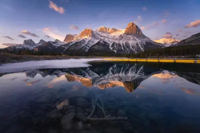 a reflection of a mountain in a lake at Skyline Escape - Mountain Views - Hot Tub - Pool in Canmore