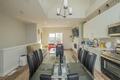 a kitchen and dining room with a table and chairs at Skyline Escape - Mountain Views - Hot Tub - Pool in Canmore