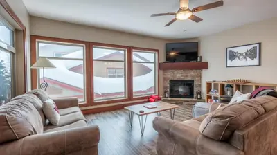 a living room with two couches and a fireplace at Mountain Time - Spacious w Private Hot Tub and an Amazing View in Big White