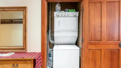 a white refrigerator in a room with a mirror at Mountain Time - Spacious w Private Hot Tub and an Amazing View in Big White