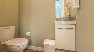 a small bathroom with a toilet and a sink at Skyline Soak - Pool & Hot Tub & Mountain Views in Canmore
