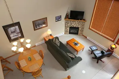 a living room with a couch and a table and a fireplace at Apartment 405 Bear Creek Crossing in Canmore