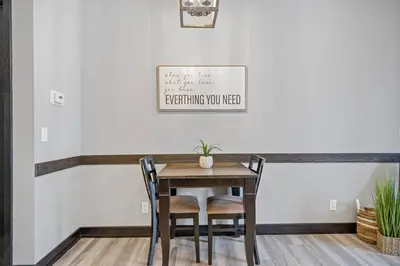 a dining room with a wooden table and chairs at Nature's Nook by Instant Suites Pool & HotTub in Canmore