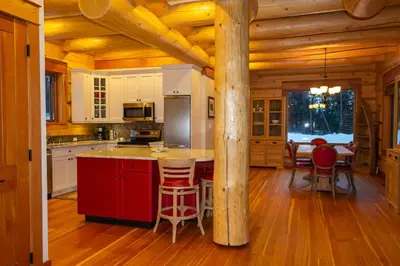 a kitchen with a red island in a log cabin at Jollymore Ranch in Smithers