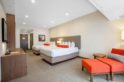a hotel room with two beds and a couch at Mountain View Inn & Suites in Sundre