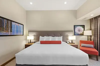 a hotel room with a large bed and two chairs at Mountain View Inn & Suites in Sundre