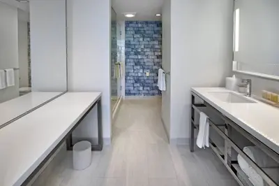 a bathroom with two sinks and a walk in shower at Renaissance Edmonton Airport Hotel in Nisku