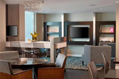 a living room with a table and chairs and a television at Renaissance Edmonton Airport Hotel in Nisku