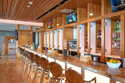 a long bar with chairs at a restaurant at Renaissance Edmonton Airport Hotel in Nisku