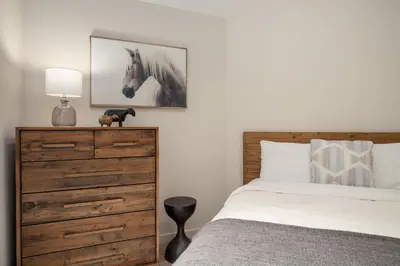 a bedroom with a bed and a dresser with a horse picture at 3BR in Snowgoose, Ski In, Luxury Property, Free Shuttle to Lifts, Parking in Whistler