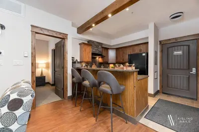 a kitchen with a bar and stools in a room at Heavenly Mountain Hideaway, Pool, Hot Tub in Radium Hot Springs