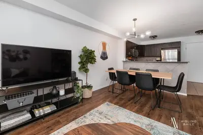 a living room with a table with chairs and a television at Chic Retreat, Modern, Pool, Hot Tub, Gym in Invermere