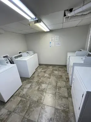an empty laundry room with white washers and dryers at Aspens on the Mountain Ski In Out in Whistler