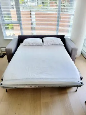 a bed in a room with a large window at Beautiful 1 BR in the Heart of Downtown: Parking, Pool & Gym in Vancouver