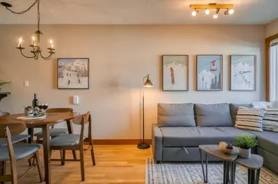 a living room with a couch and a table at Incredible Mountain View Townhouse in DT Canmore w/ A/C & U/A Parking in Canmore