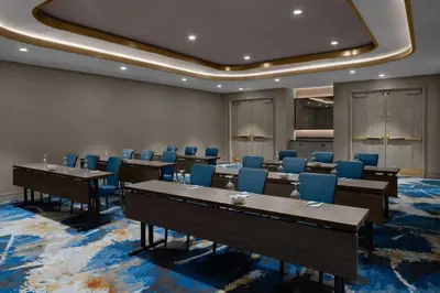 a conference room with tables and blue chairs at Courtyard by Marriott Calgary Downtown in Calgary
