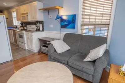 a living room with a couch and a kitchen at Downtown Whitehorse Apartment in Old Town in Whitehorse