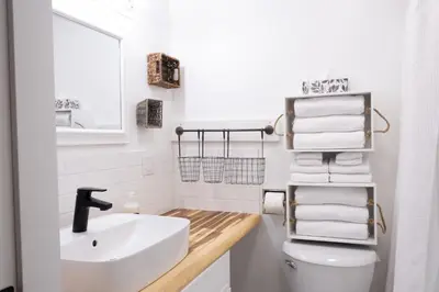 a bathroom with a sink and a toilet and towels at Harrison On The Lake, Walkable to Beach and Village in Harrison Hot Springs