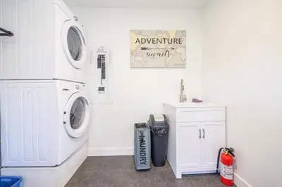 a white laundry room with a washer and dryer at Storm Bay, Family Home with Hot Tub and Inlet View in Ucluelet