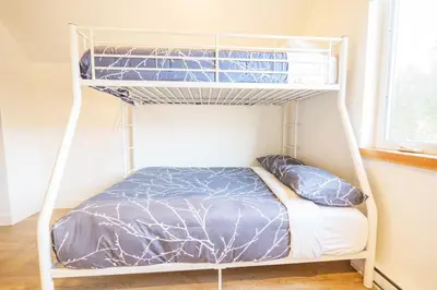 a white bunk bed in a room with a window at Storm Bay, Family Home with Hot Tub and Inlet View in Ucluelet