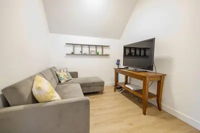 a living room with a couch and a flat screen tv at Storm Bay, Family Home with Hot Tub and Inlet View in Ucluelet