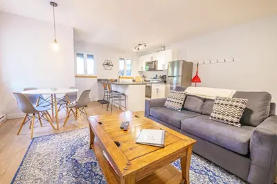 a living room with a couch and a table at Storm Bay, Modern 1 Bed Suite and Chefs Kitchen in Ucluelet