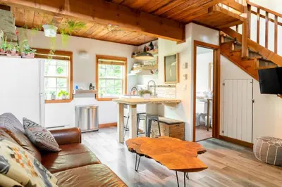 a living room with a couch and a table at Fern Gully, Coastal Bohemian Loft at Beach in Ucluelet