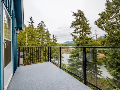 a balcony with a view of a river at Kingfisher, Waterfront Cabin with Inlet with Mountain Views in Ucluelet