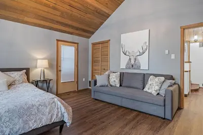 a bedroom with a bed and a couch at Canmore Cabin by Canadian Rockies Vacation Rentals in Canmore