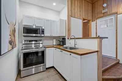 a kitchen with white cabinets and a sink and a stove at Canmore Cabin by Canadian Rockies Vacation Rentals in Canmore