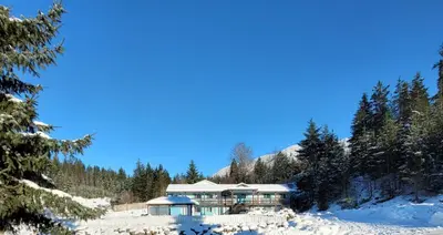 a house in the snow with snow covered trees at Ridgeview Motor Inn in Gold River
