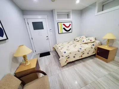 a bedroom with a bed and a table and two lamps at Cozy Guest Suite in Quiet Home with Private Entry in Vancouver
