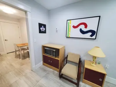 a living room with a tv and a chair and a table at Cozy Guest Suite in Quiet Home with Private Entry in Vancouver