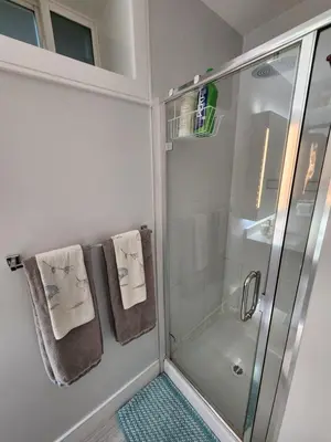 a bathroom with a shower and towels on a wall at Cozy Guest Suite in Quiet Home with Private Entry in Vancouver