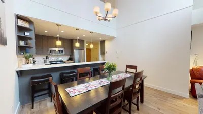 a dining room and kitchen with a table and chairs at Greyhawk by Whistler Premier in Whistler