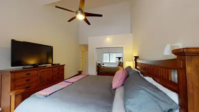 a bedroom with a bed and a flat screen tv at Greyhawk by Whistler Premier in Whistler