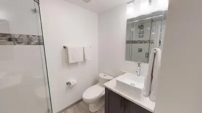 a white bathroom with a toilet and a sink at Greyhawk by Whistler Premier in Whistler