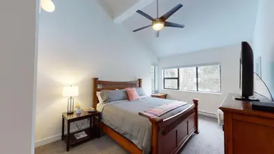 a bedroom with a bed and a flat screen tv at Greyhawk by Whistler Premier in Whistler
