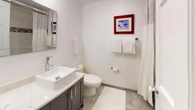 a white bathroom with a sink and a toilet at Greyhawk by Whistler Premier in Whistler