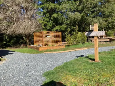 a sign on the side of a gravel road at The Hiker Huts in Port Renfrew