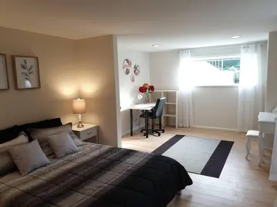 a bedroom with a bed and a desk and a deskablish at Happy, Cozy, Loving Guest Space in West Vancouver in West Vancouver