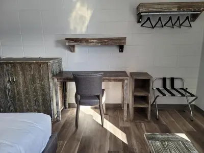 a bedroom with a desk and a chair and a bed at Parkside Inn in Grande Prairie