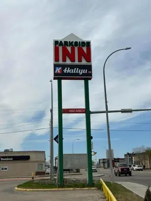 a sign for azona inn in a parking lot at Parkside Inn in Grande Prairie