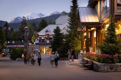 a group of people walking down a street in a town at Whistler Village Centre by Whiski Jack in Whistler